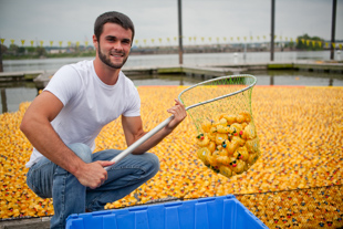 Matt Monroe of Morton helps to scoop up the nearly 25,000 rubber ducks from the Illinois River after the 24th annual Duck Race to stop abuse to benefit the Center for Prevention of Abuse. This is his second year to volunteer for the event.