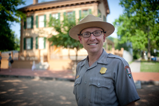 Ronnie Van Nostrand stands in front of the Lincoln Home in Springfield, IL.  Ronnie got his degree in history on the 'GI Bill' after serving 8 years in the Army.  He has been a guide for the National Park Service for 8 months.