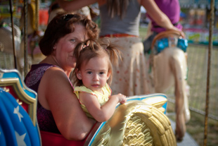 1 year old Elle Olson rides the carousel at Dunlap Days with her grandmother Theresa Strode.