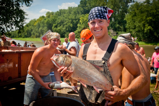 T. J. Pratt of Beardstown, IL holds one of the 166 Asian Carp he and his team caught during the Original Redneck Fishing Tournament in Bath, IL.  T. J. is also a college student and Volunteer firefighter.